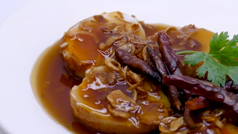 close-up footage of son in law egg , deep fried egg with sweet and sour tamarind sauce, topping with dried chilli, thai famous dish