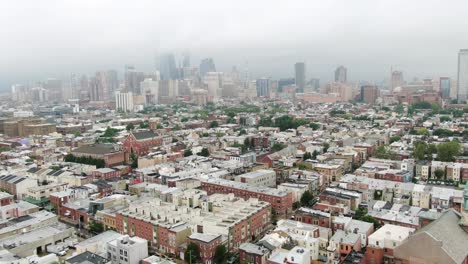 philadelphia skyline, housing community on cloudy rainy foggy humid summer day, aerial drone shot above south philly neighborhood