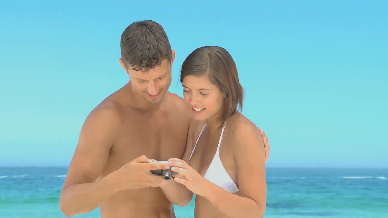 hermosa pareja tomando fotos en una playa