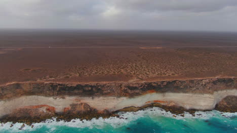 Camper-Van-Driving-on-Empty-Coastal-Highway,-Nullarbor-Cliffs,-Australia,-Wide-Angle-Side-Tracking-Drone-Shot