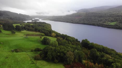 Flug-über-Bäume-Am-Ufer-Des-Green-Valley-Mit-Loch-Tummel-Im-Hintergrund