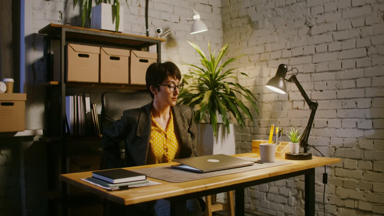 mujer trabajando hasta tarde en una oficina en el hogar