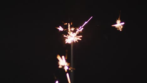 video de un centelleador encendido quemándose sobre un fondo negro, con espacio para copiar