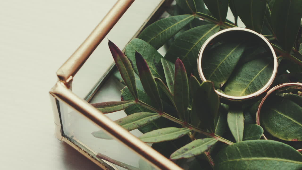 Close-Up of Gold Wedding Rings with Flowers