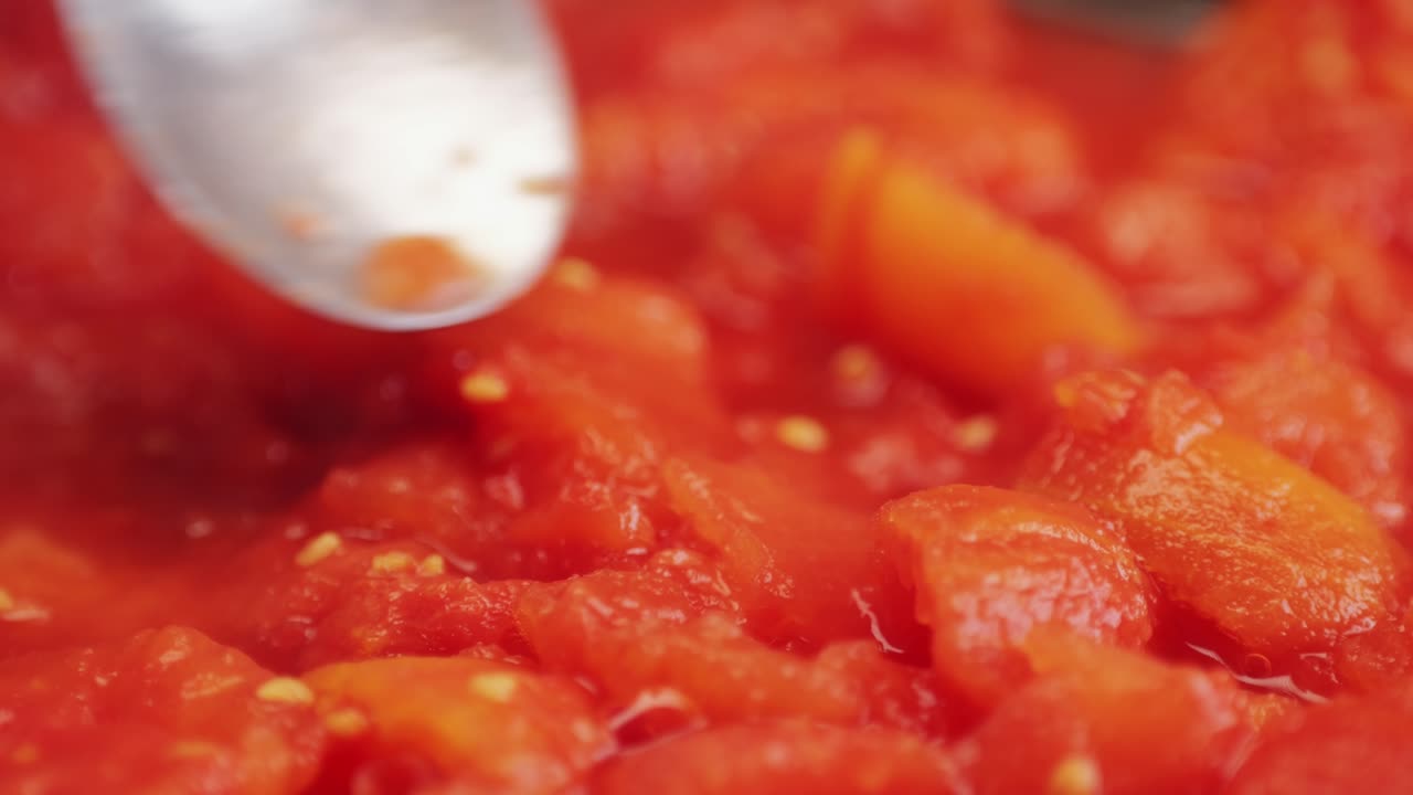 Cooking fresh peeled canned tomato Juice sauce with mozzarella cheese in pan, peeled tomatoes boiling in their own juice, making tomatoes pasta sauce .Top view close up, Italian traditional cuisine food.