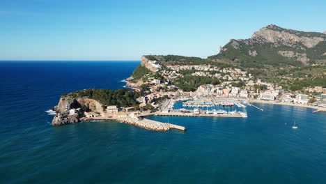 luxury harbour with mega yachts sailing boats and beach clubs with beaches and beautiful ocean on spanish tropical island mallorca port soller aerial shot