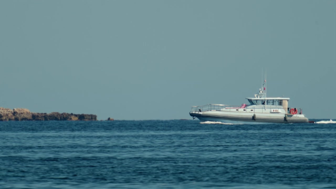 Motovedetta che si muove sulla superficie dell'oceano, creando una scia. Raffigurante la sicurezza marittima, la guardia costiera e i viaggi nautici, Antibes, Francia.
