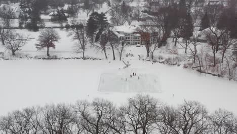 aerial, family and friends playing ice hockey on a homemade skating rink at backyard pond