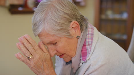 elderly woman in prayerful pose