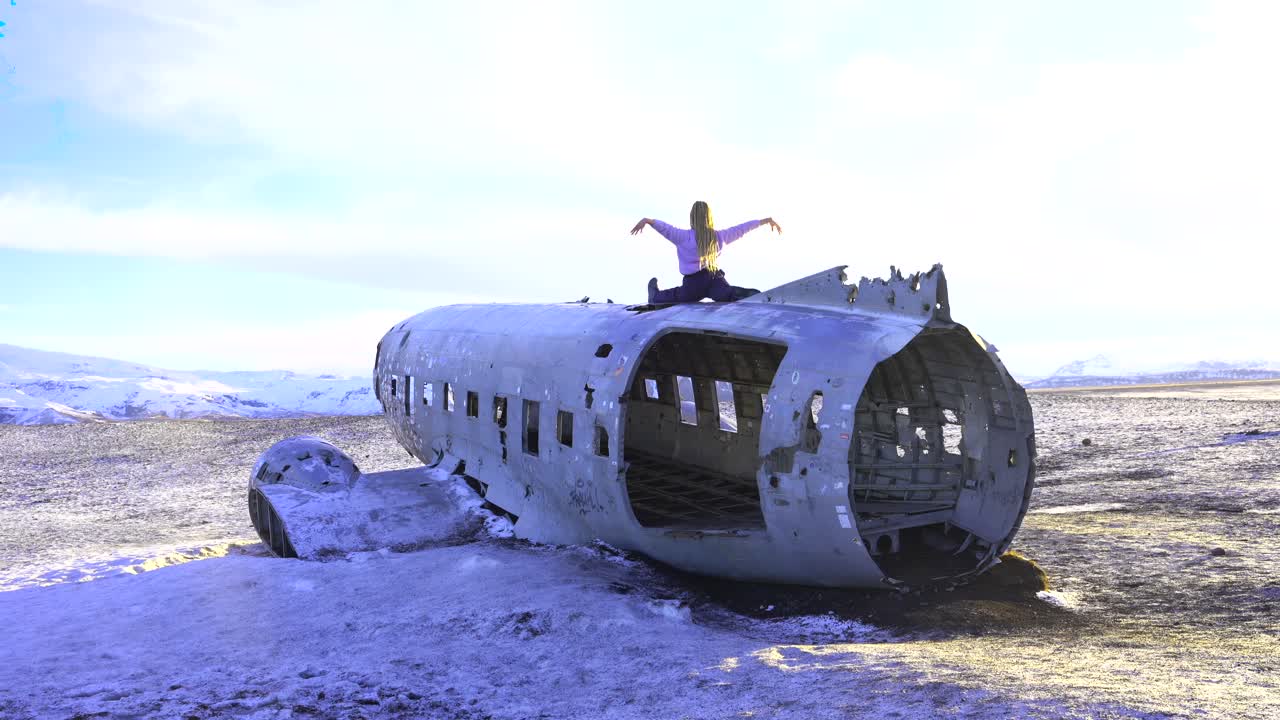 Donna che pratica yoga su un relitto di un aereo in Islanda