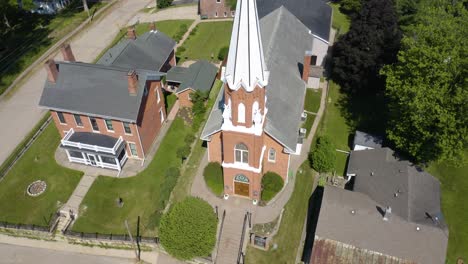 Top-Down-Aerial-Shot-of-Church-with-Steeple-in-Rural-Town-on-Main-Street