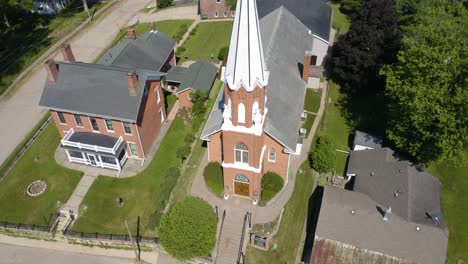 top down aerial shot of church with steeple in rural town on main street