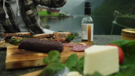 Close-up-of-person-taking-food-from-picnic-in-the-mountains