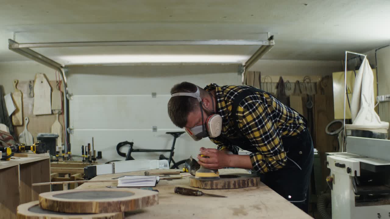 carpintero que lijaba una losa de madera en un taller