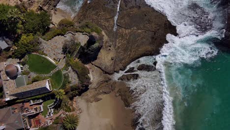 aerial view looking down on cliff side housing, on the edge of the pacific ocean