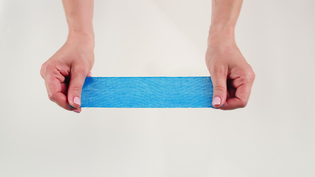 Kinesiology medical taping, doctor Physical therapist applying elastic surgical tape to patient body, treating injured knee young athlete.Post traumatic rehabilitation, sport physical therapy recovery