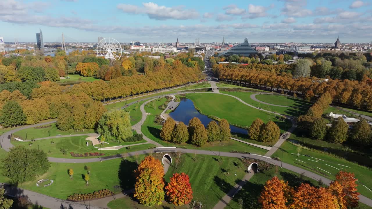 Establishing shot of Riga park with blue sky, clouds, and vivid fall colors
