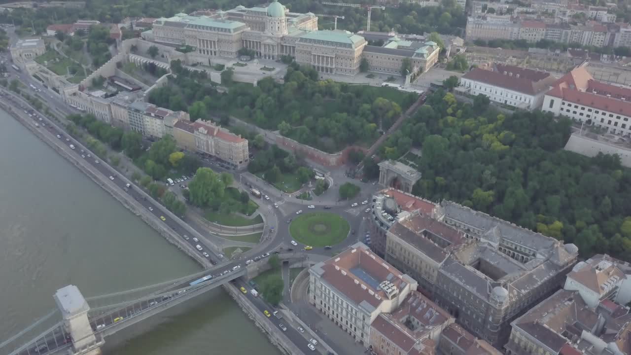 Vista aerea del traffico cittadino sulla rotonda vicino al Ponte delle Catene Szechenyi e al Palazzo del Parlamento. Le auto guidano sulla strada circolare e sulla strada lungo il fiume. Edifici storici. Budapest, Ungheria, Europa.