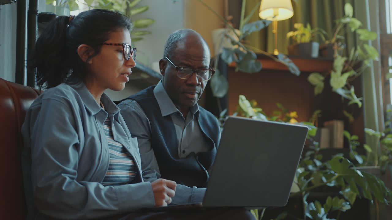 Female Student Using Laptop and Talking with Senior Teacher