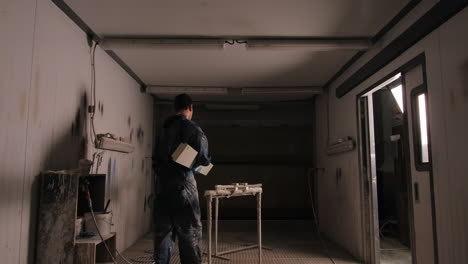 worker spray painting in a paint booth