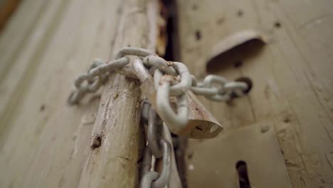 abandoned house with padlock chain wooden door and fast tilt camera movement