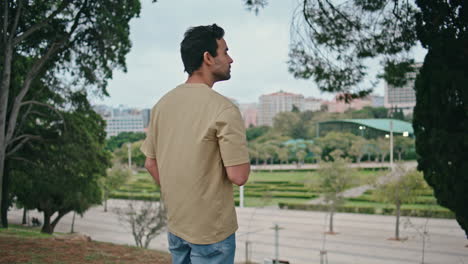 attractive guy resting park holding coffee cup. hispanic man drinking beverage