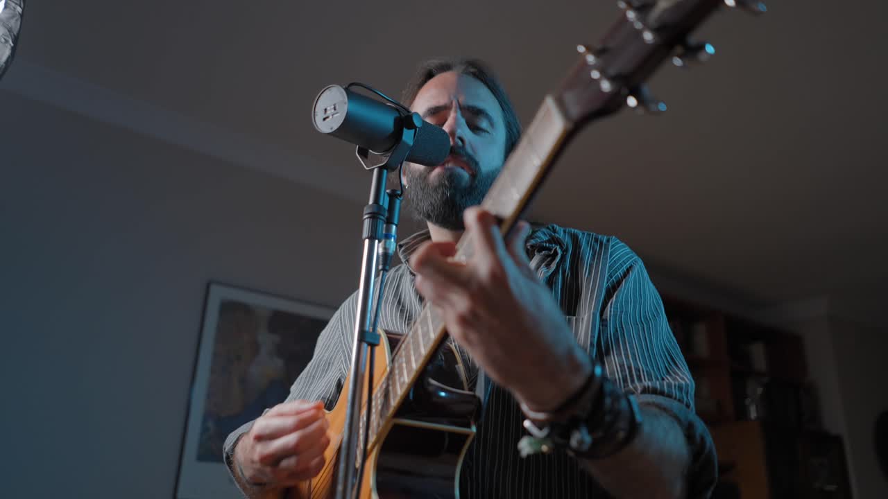 hombre cantando y tocando la guitarra acústica