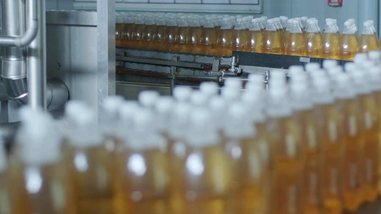 현대 음료 공장에서 주스 또는 물을위한 병을 가진 컨베이어 벨트 - 달한 소다 물의 현대 생산