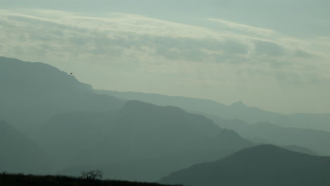 Eagle-flying-near-the-clouds-in-a-beautiful-valley-with-mountains-full-of-mist