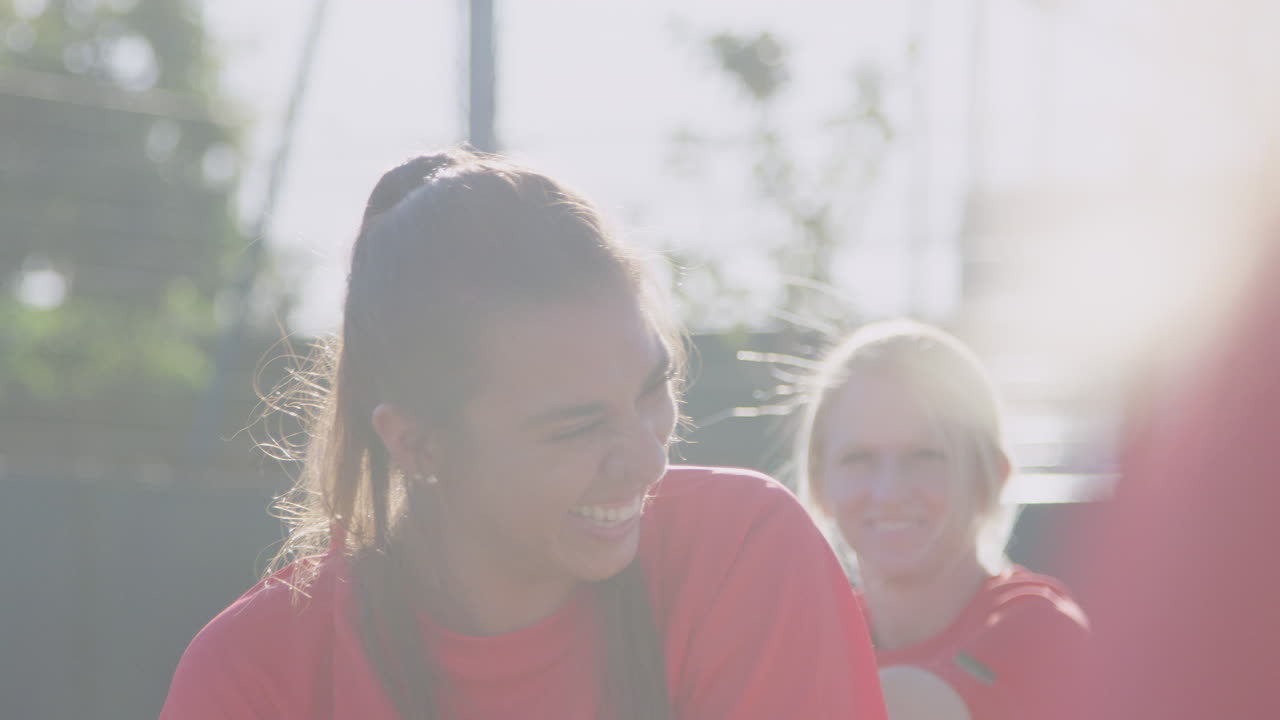 여자 축구 팀 이 경기 전 열기 훈련 중 휴식 기간 에 대화 하고 있다