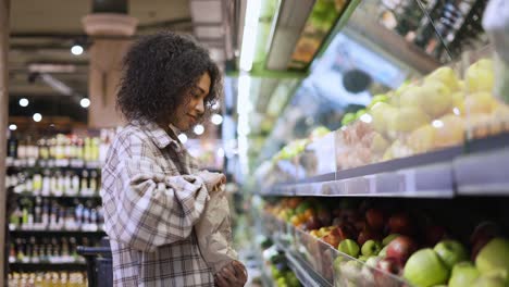 Fröhliche-Frau,-Die-Im-Supermarkt-Frische-Äpfel-In-Eine-Papiertüte-Wählt