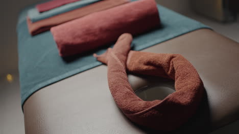 stacked and rolled towels on massage table