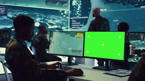 Intelligence-analyst-reviews-ships-activity-next-to-an-isolated-mockup-screen