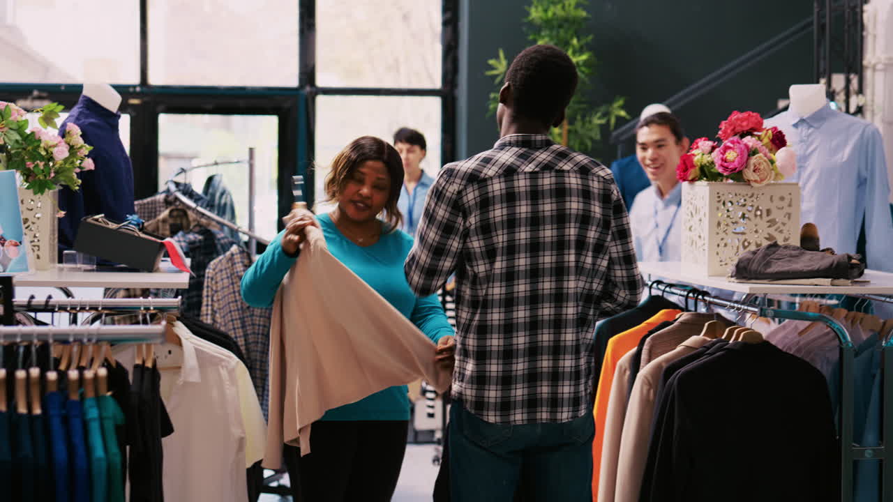 옷을 입은 고객을 돕는 매니저