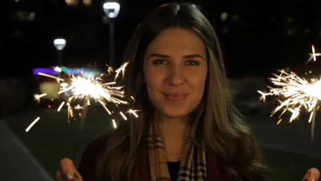 mujer disfrutando de chispas en la noche