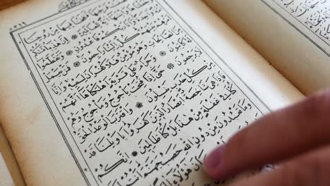 a person is leafing through a quran