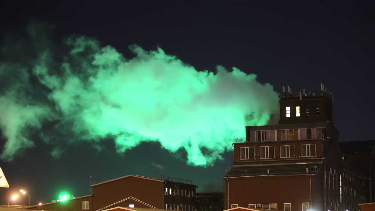 밤의 굴에서 나오는 녹색 연기가 공장에서 나오는 탄소 배출과 함께 산업 도시 풍경입니다.