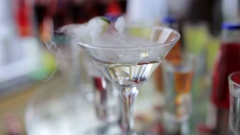 smoking martini cocktail in a conical glass with wafting vapor smoking martini cocktail in a conical glass with wafting vapor