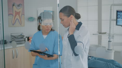 dentist and assistant analyzing modern tablet screen