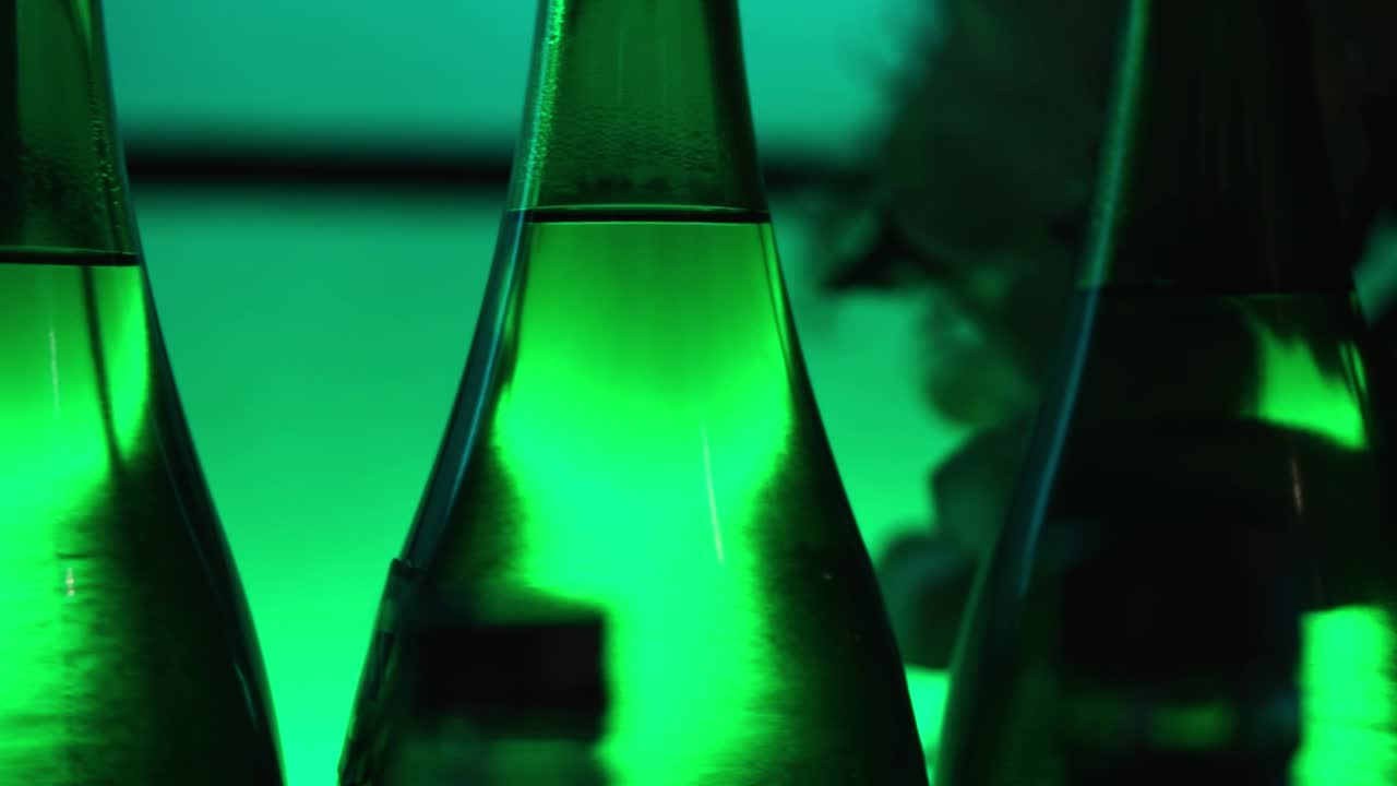 cacerola lenta a través de botellas de sake con luz verde en un restaurante japonés