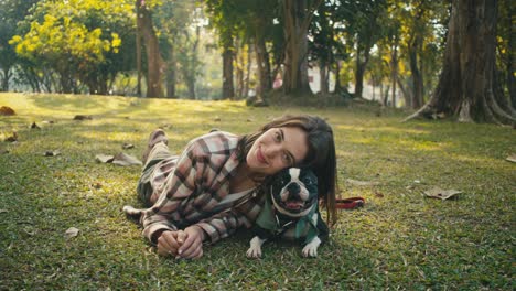woman and boston terrier in a park