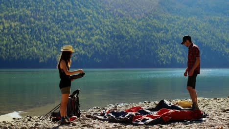 hiker couple preparing tent near riverside 4k