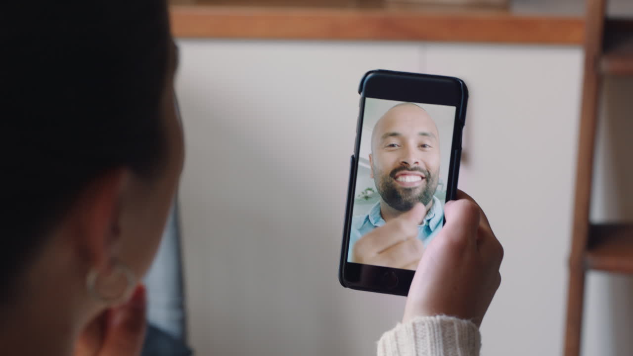 mujer joven usando un teléfono inteligente teniendo video chat con su novio sordo comunicándose usando lenguaje de señas gestos con las manos disfrutando de la comunicación en línea