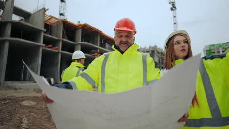 two professional civil engineers are discussing building object aged foreman and young woman