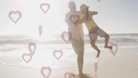 father playing with child on beach, hearts animation over sunny background