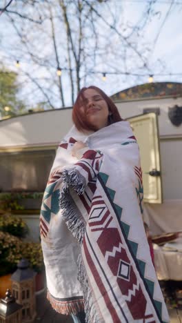 woman enjoying a cozy autumn day by a trailer