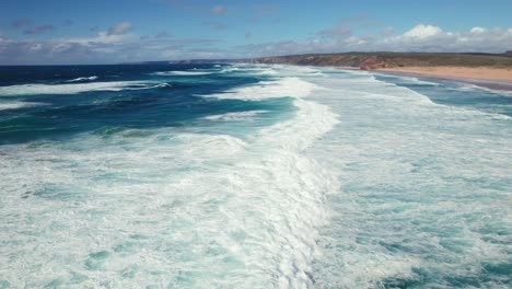 Moving-with-waves-makes-it-appear-as-if-the-waves-are-motionless-Aerial-4k-drone-shot-of-continuous-waves-at-praia-da-Cordoama-hidden-cliff-coastline-near-the-Algarve-region-of-Portugal