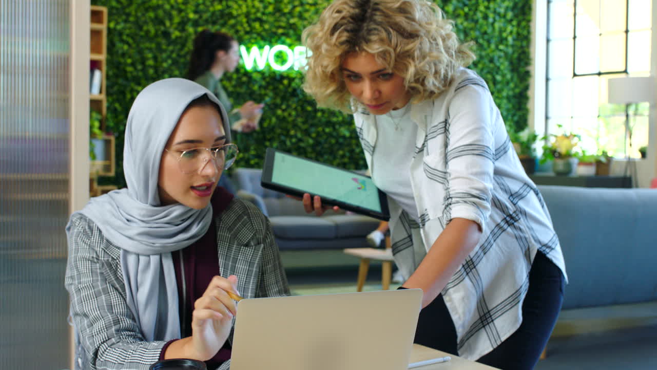 Creative muslim employee talking to manager