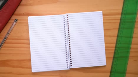 male hands turning blank pages of a notebook on the table