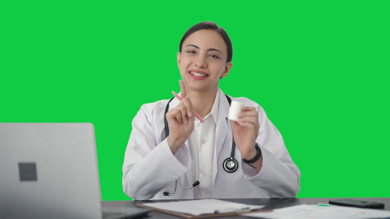 행복 한 인도 여성 의사 는 환자 에게 약 을 주는 녹색 스크린